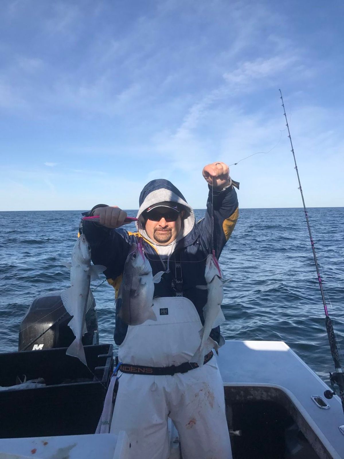 a man holding a fish on a boat in the water