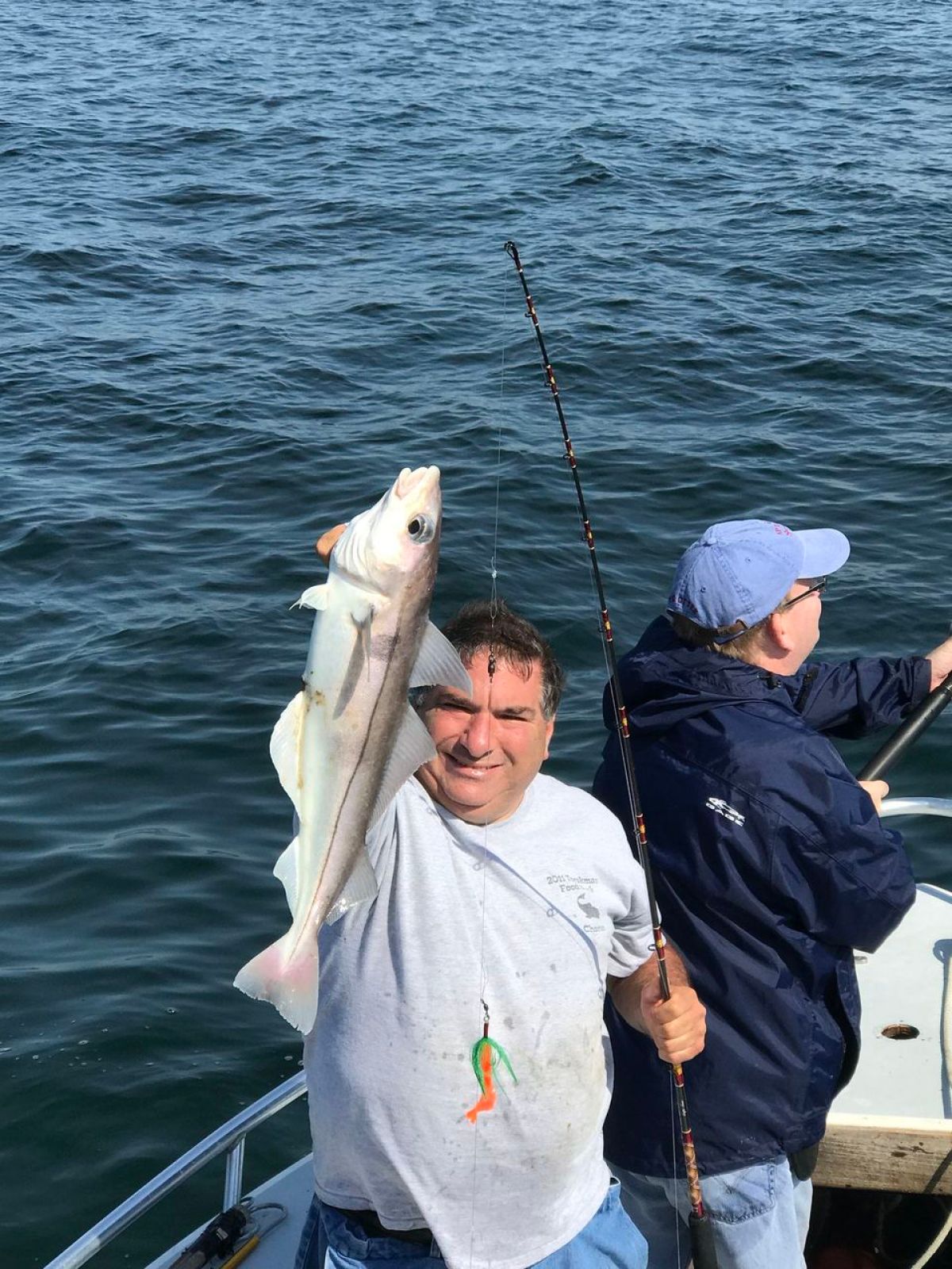 a person holding a fish on a boat in a body of water