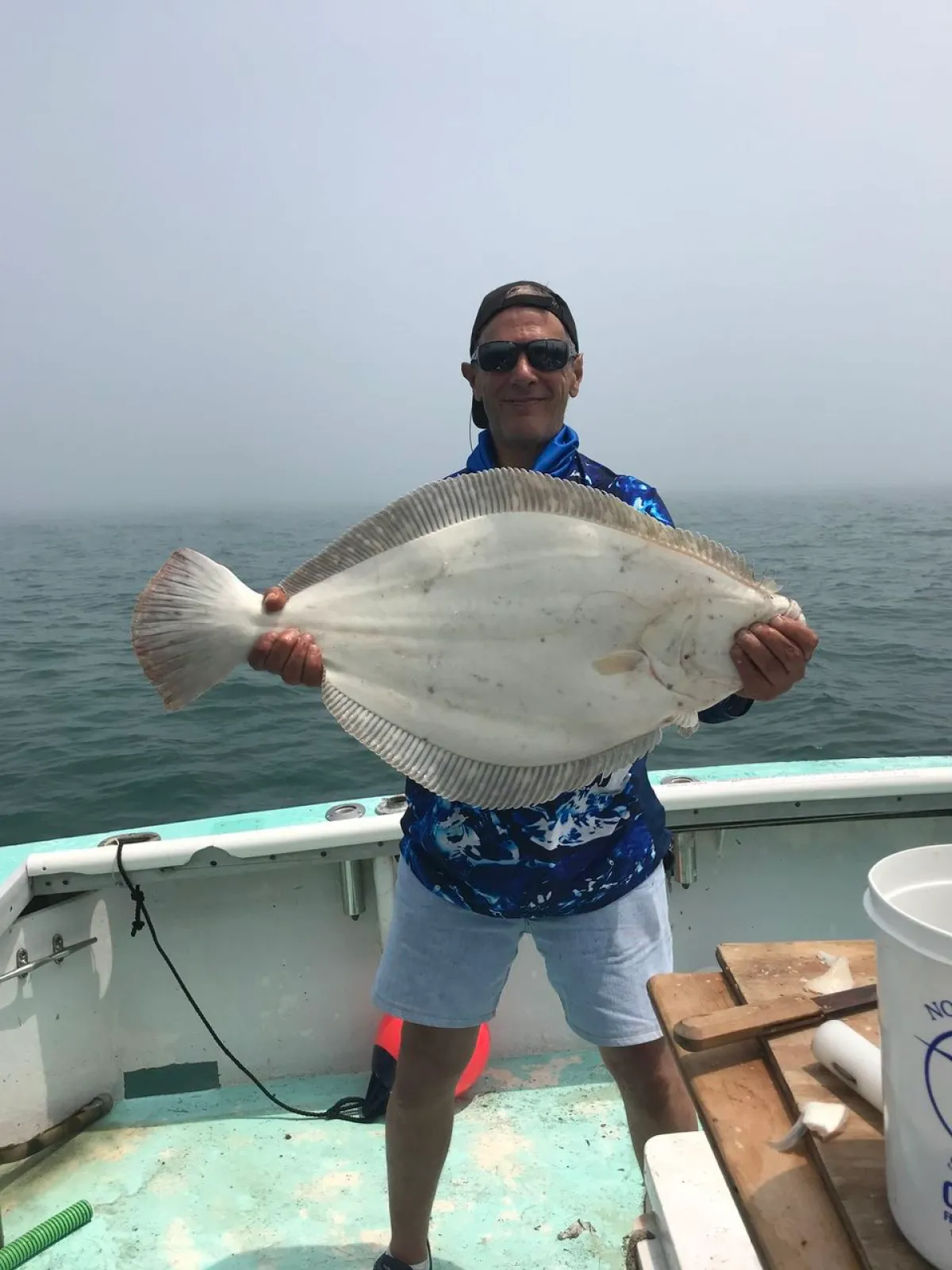 a man holding a fish on a boat in the water