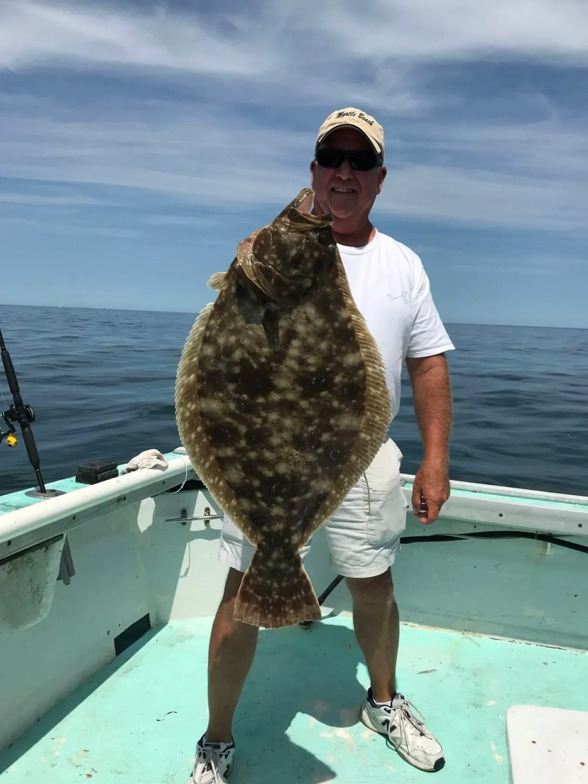 a man holding a fish on a boat in the water