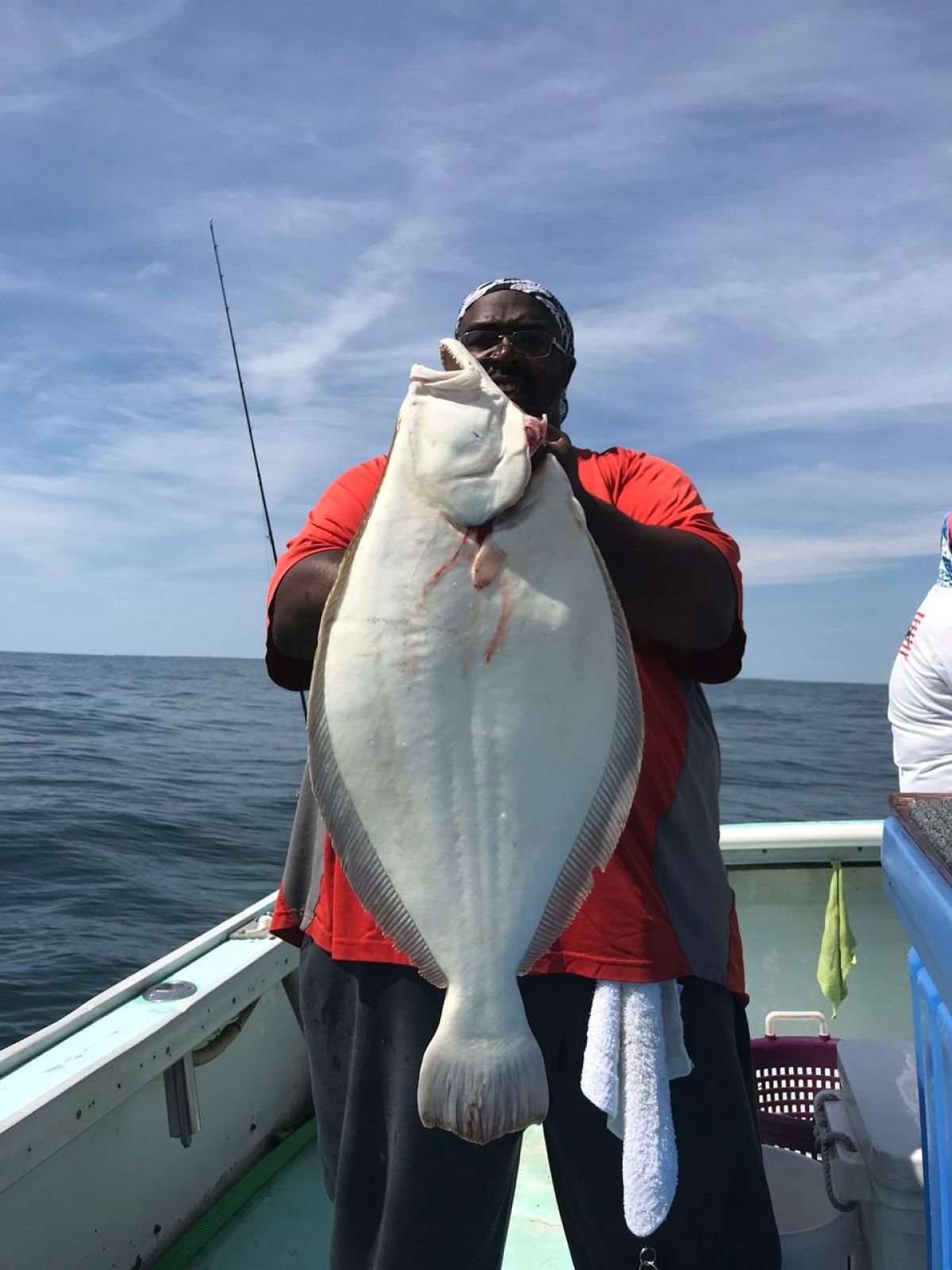 a person holding a fish on a boat in a body of water