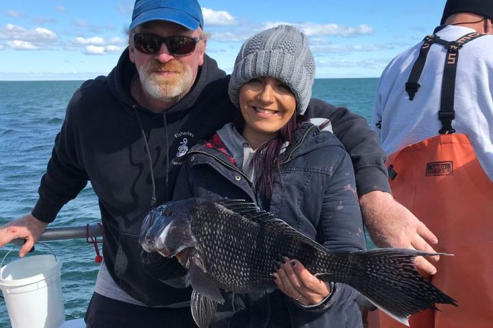 a group of people standing next to a body of water