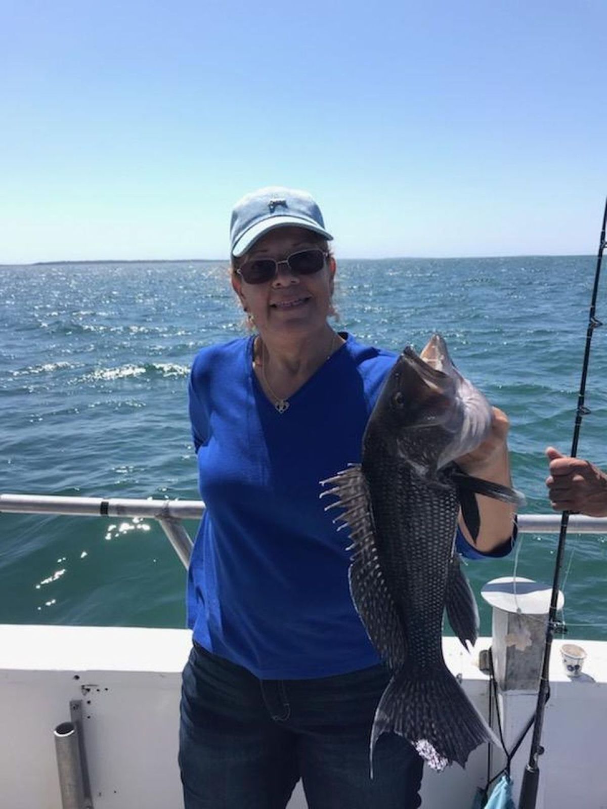 a person holding a fish on a boat in a body of water