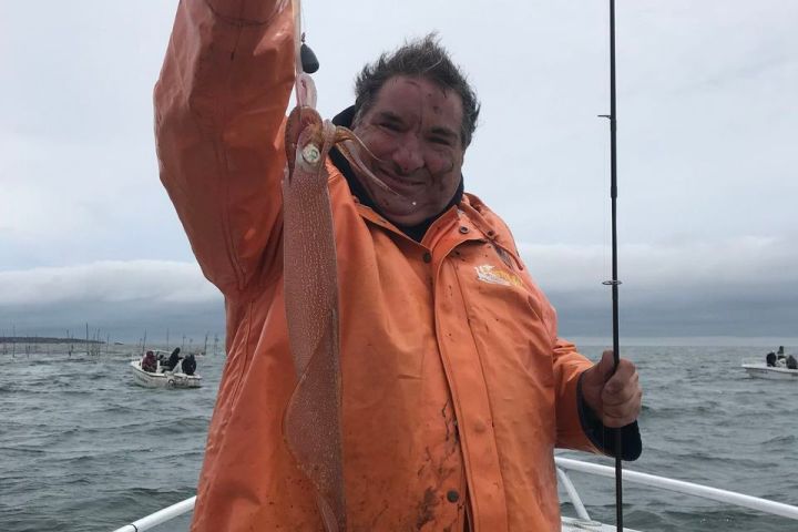 a woman standing next to a body of water