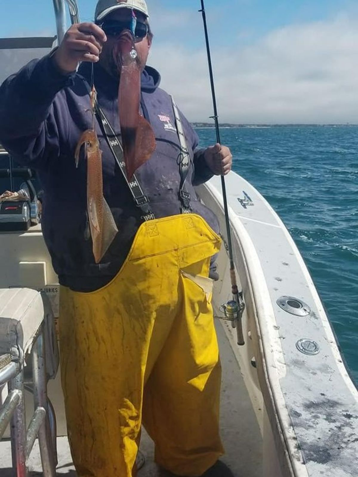 a man holding a fish on a boat