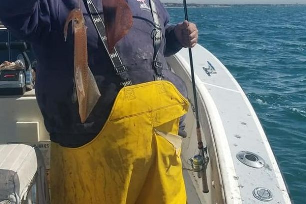 a man holding a fish on a boat