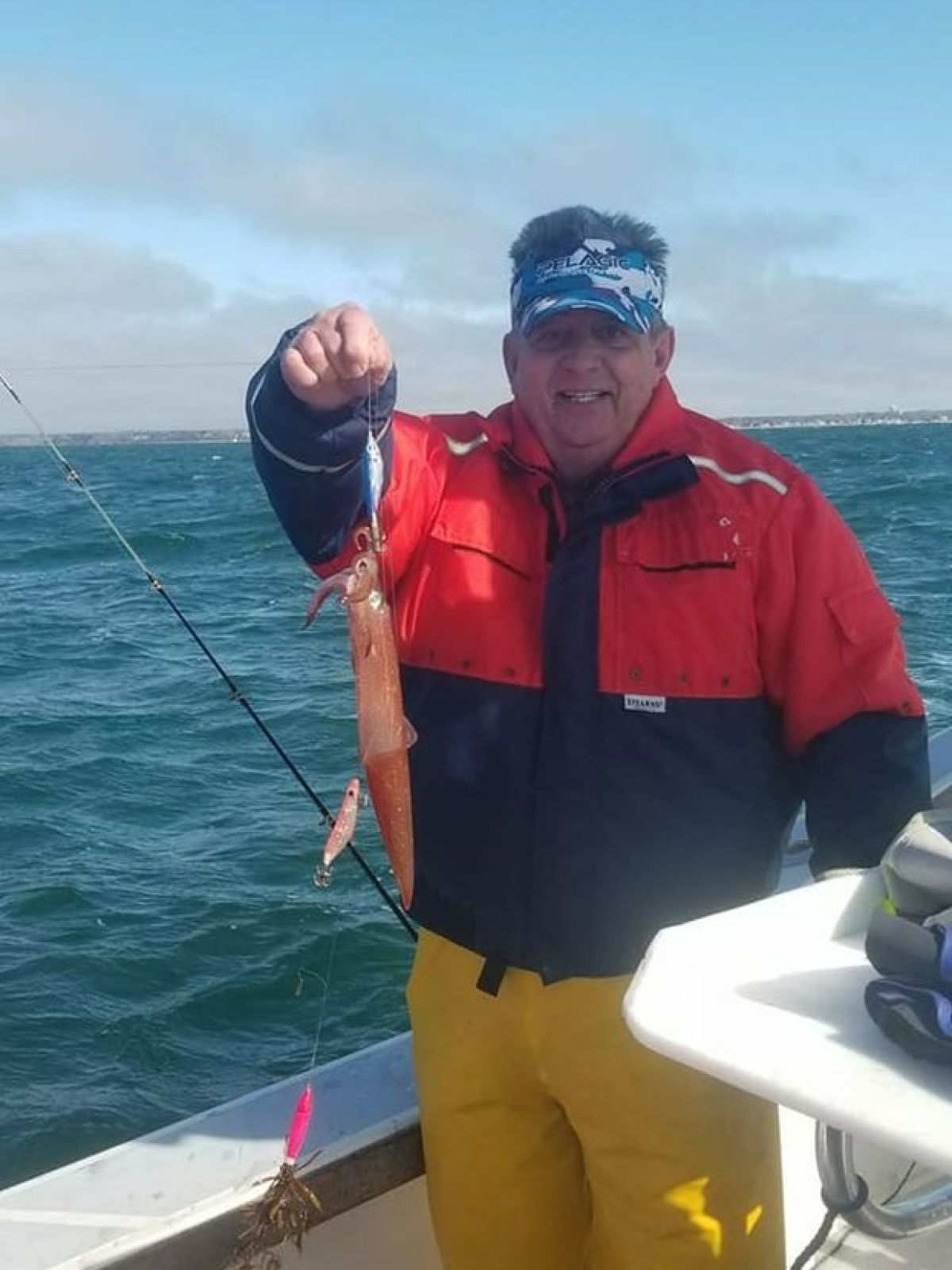 a man holding a fish on a boat in the water