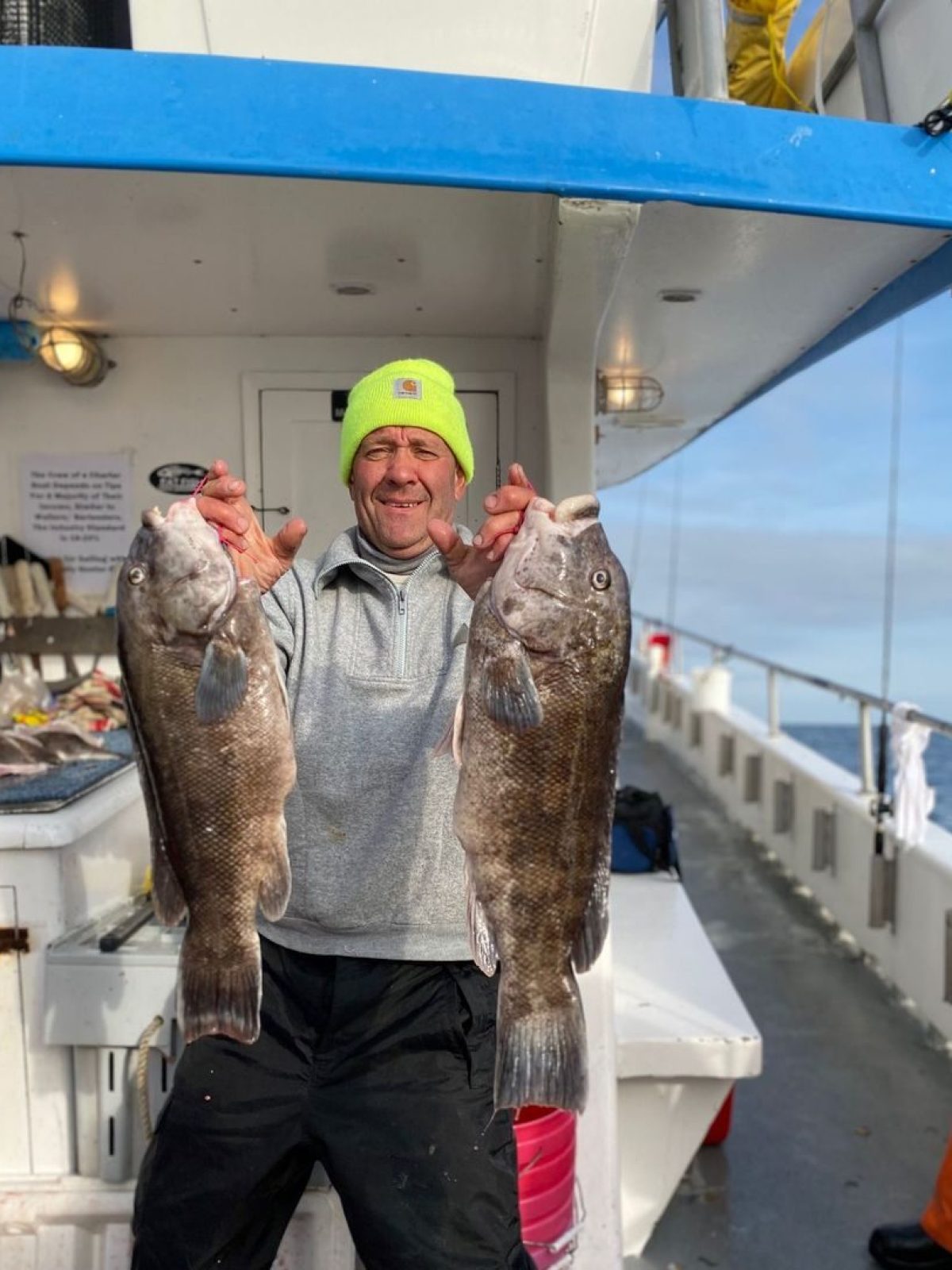 a man holding a fish on a boat
