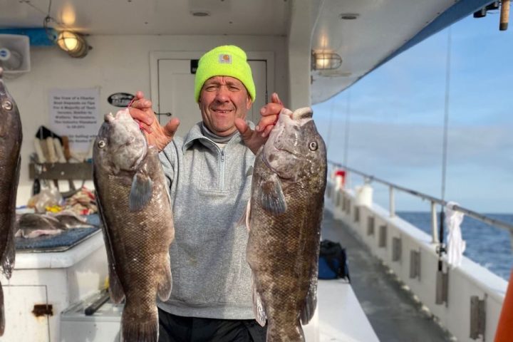 a man holding a fish on a boat